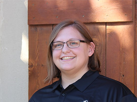 Caucasian woman with brown hair wearing glasses and smiling for the camera