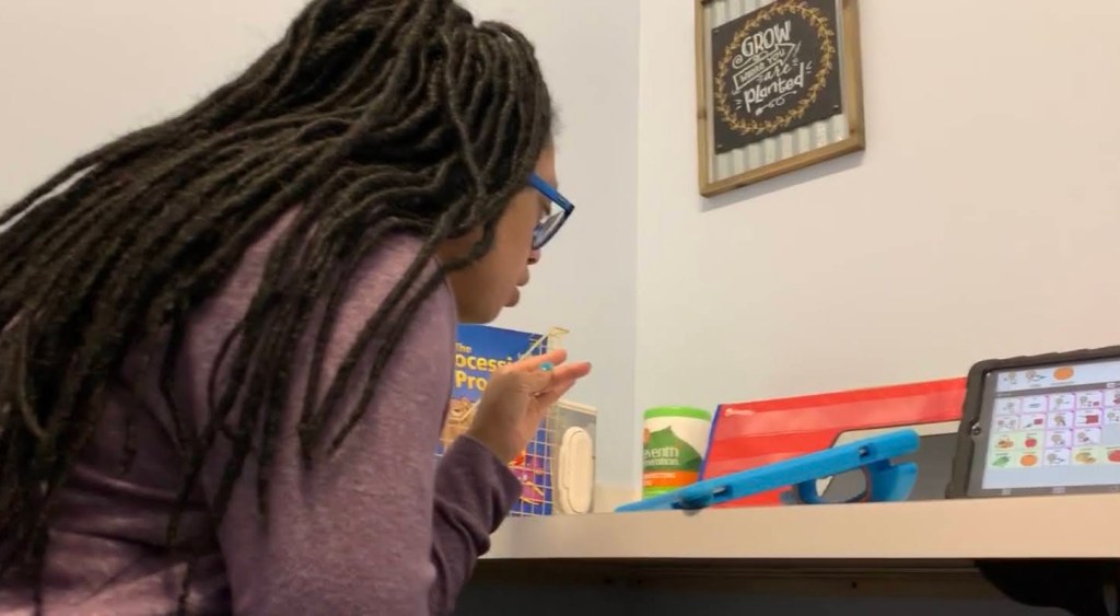 A woman with long hair using a communication device